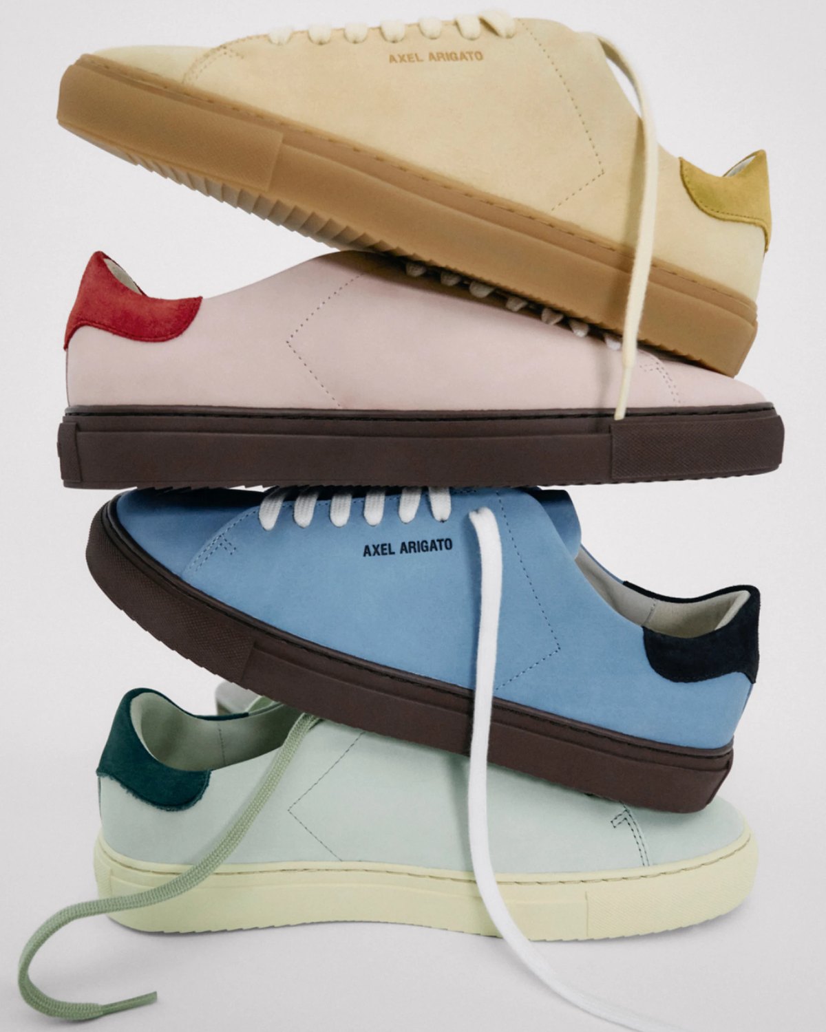 Axel Arigato clean leather sneaker in hand.