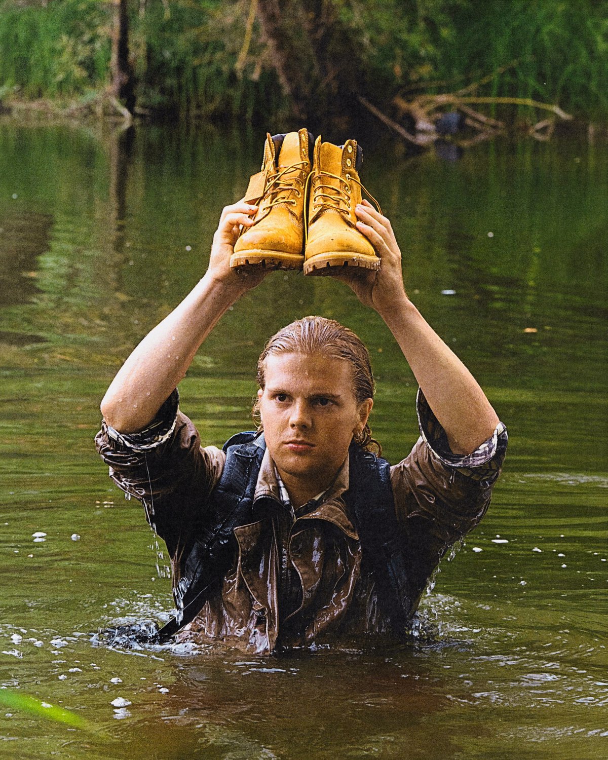 Protagonist in the water, boots overhead.