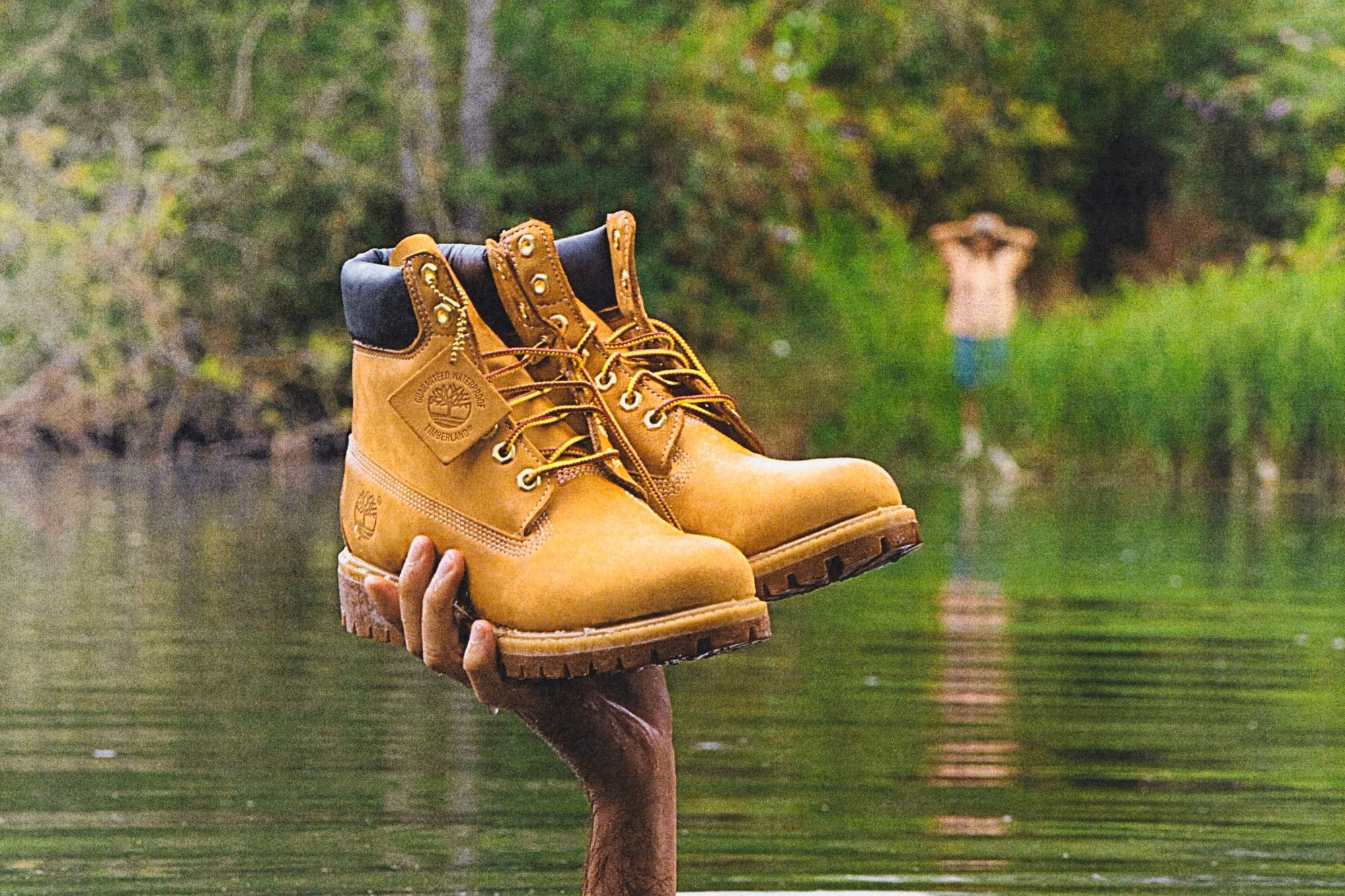 Timberland boots held above water, the product as hero.